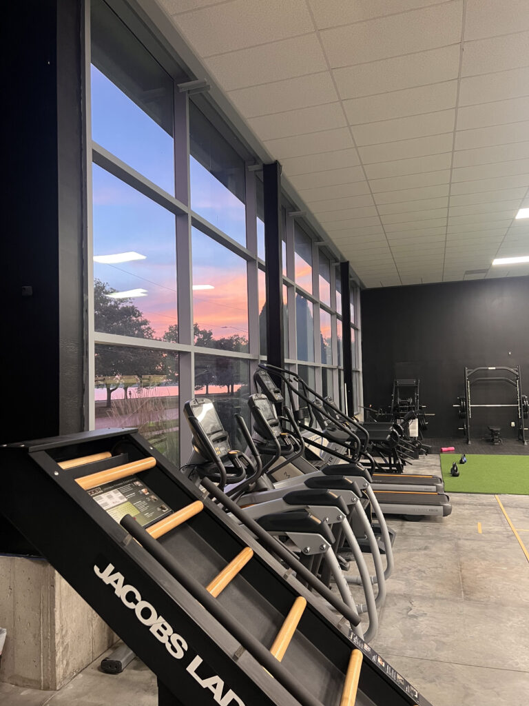 Cardio equipment beside the gym windows